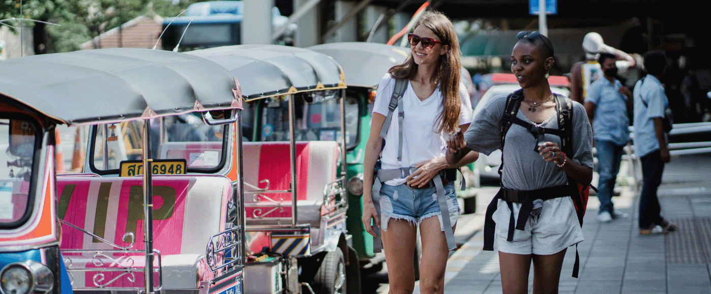 Interview deltagere Nicole og Claire der går ved siden af tuk-tuks i Thailand